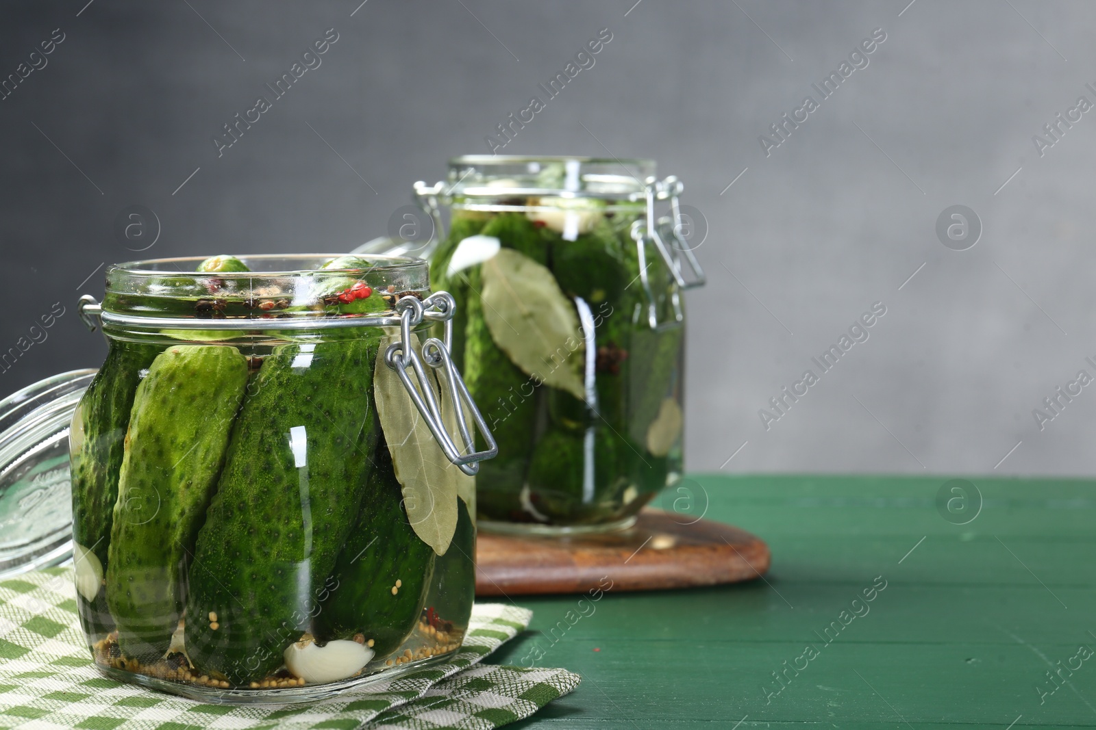 Photo of Making pickles. Fresh cucumbers and spices in jars on wooden table. Space for text