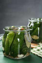 Photo of Making pickles. Fresh cucumbers and spices in jars on wooden table