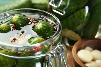 Photo of Making pickles. Fresh cucumbers and spices in jar, closeup