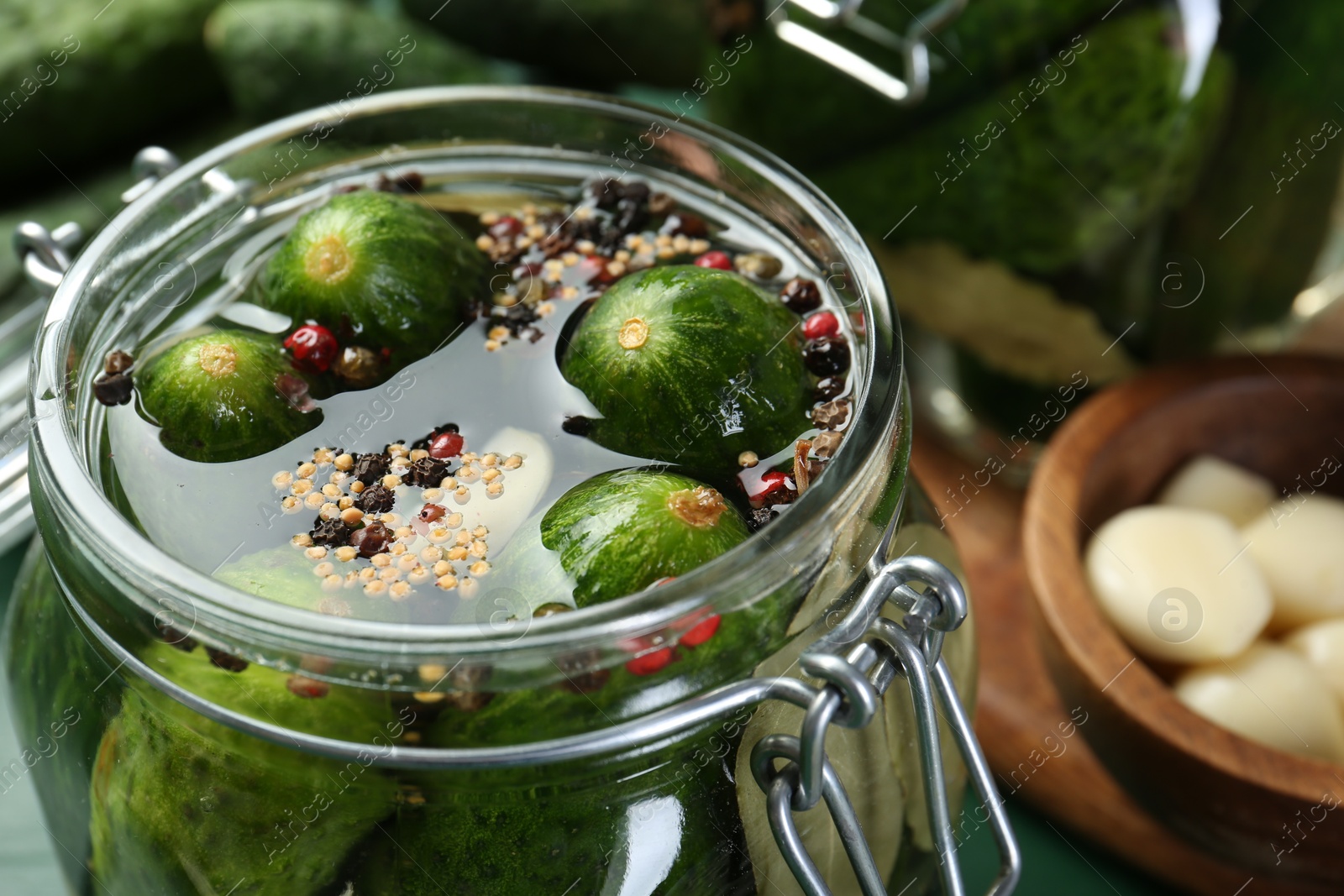 Photo of Making pickles. Fresh cucumbers and spices in jar, closeup