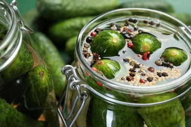 Photo of Making pickles. Fresh cucumbers and spices in jar, closeup