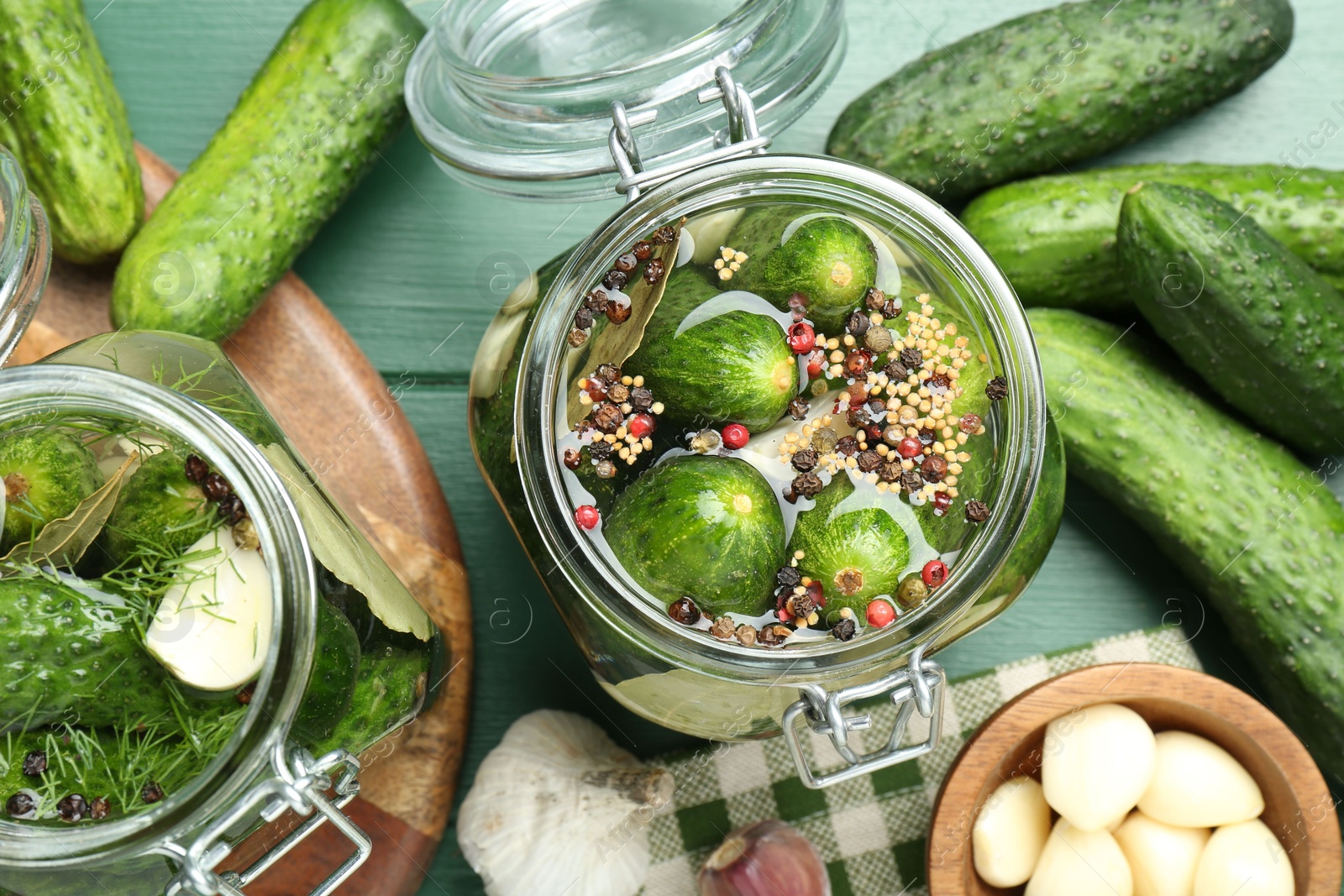 Photo of Making pickles. Fresh cucumbers and spices in jar on wooden table, flat lay