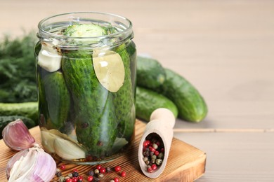 Photo of Making pickles. Fresh cucumbers and spices in jar on wooden table, closeup. Space for text