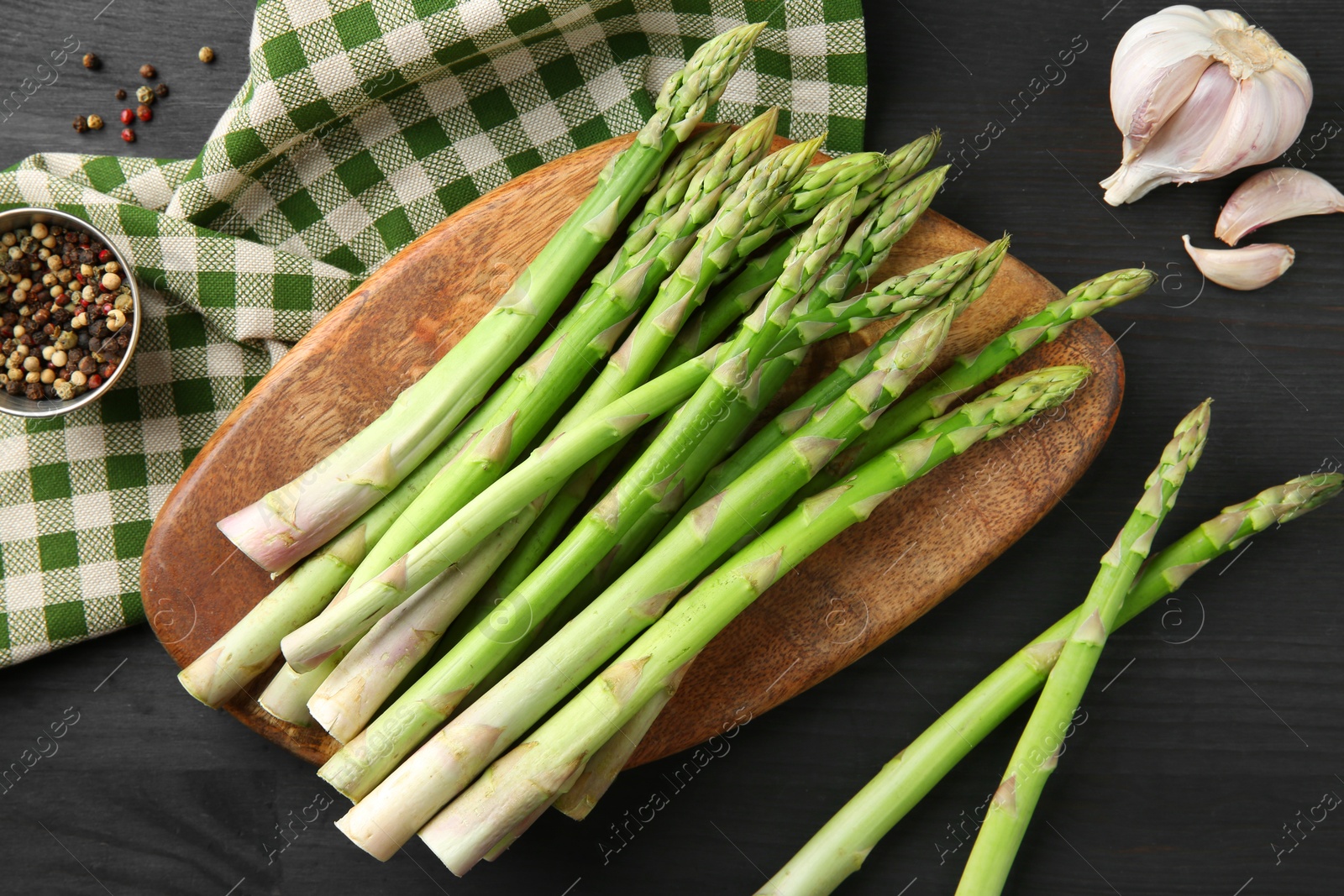 Photo of Fresh green asparagus stems and spices on gray wooden table, flat lay