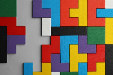 Colorful wooden puzzle pieces on light grey background, top view