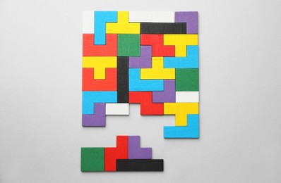 Photo of Colorful wooden puzzle pieces on light grey background, top view