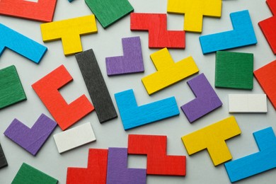 Colorful wooden puzzle pieces on light grey background, top view