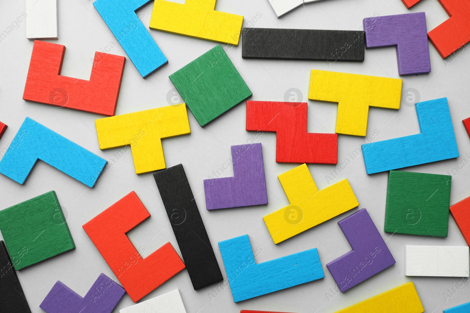 Photo of Colorful wooden puzzle pieces on light grey background, top view