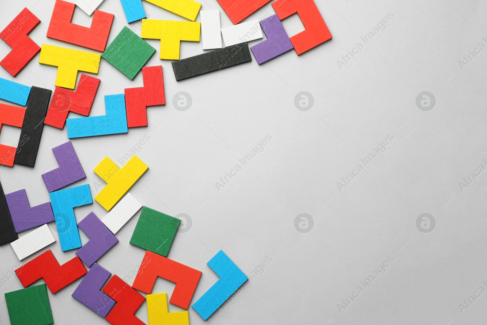 Photo of Colorful wooden puzzle pieces on grey background, top view. Space for text