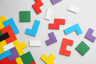 Colorful wooden puzzle pieces on light grey background, top view