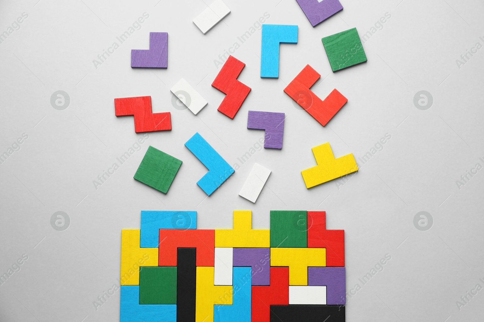 Photo of Colorful wooden puzzle pieces on light grey background, top view