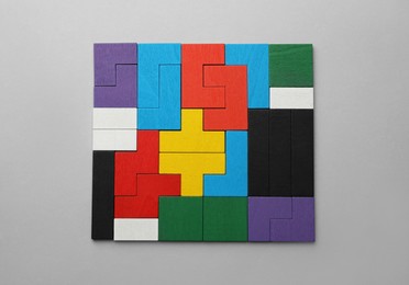 Photo of Colorful wooden puzzle pieces on light grey background, top view