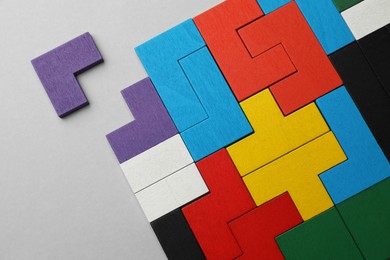 Photo of Colorful wooden puzzle pieces on light grey background, top view