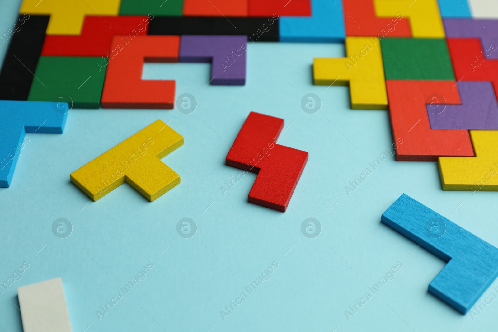 Photo of Colorful wooden puzzle pieces on light blue background