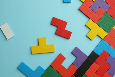 Photo of Colorful wooden puzzle pieces on light blue background, top view