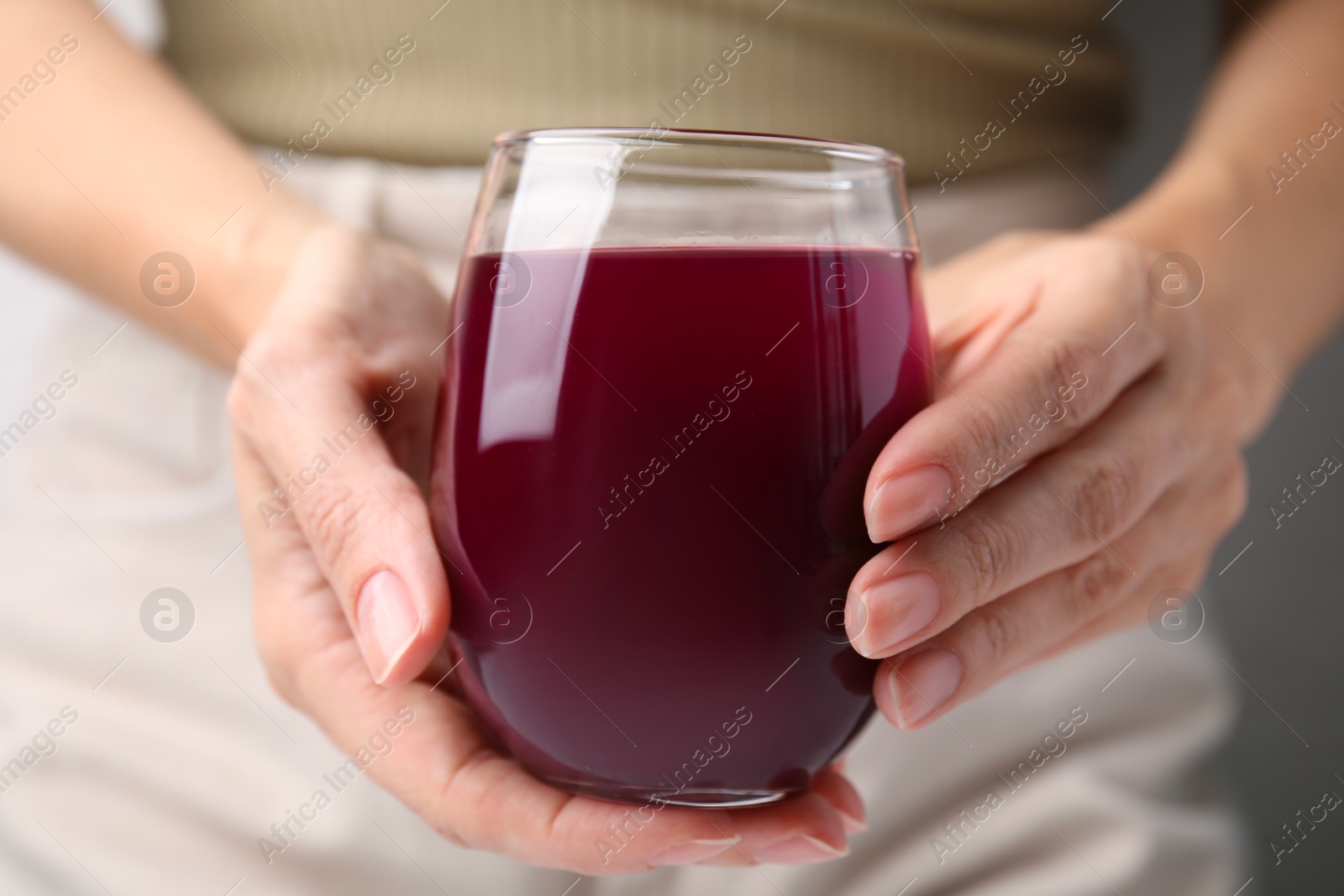 Photo of Woman with glass of fresh beet juice, closeup