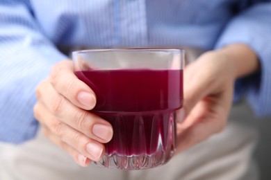 Photo of Woman with glass of fresh beet juice, closeup