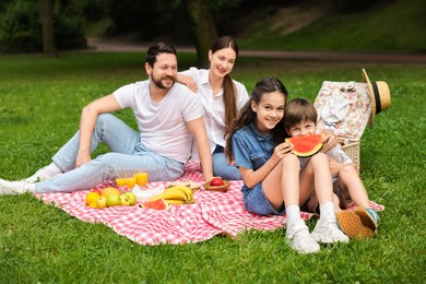 Happy family having picnic together in park