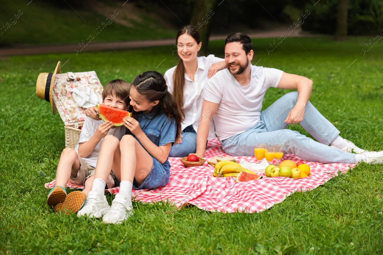 Photo of Happy family having picnic together in park