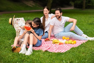 Photo of Happy family having picnic together in park