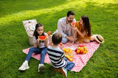 Happy family having picnic together in park