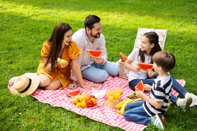 Photo of Happy family having picnic together in park