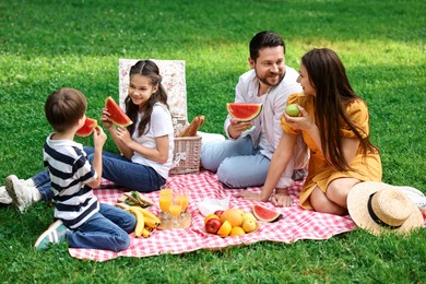 Happy family having picnic together in park