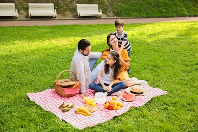 Happy family having picnic together in park