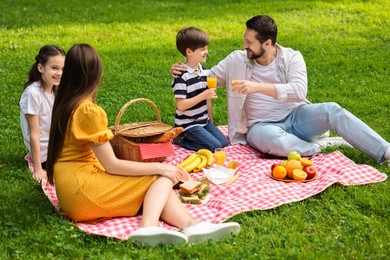 Happy family having picnic together in park