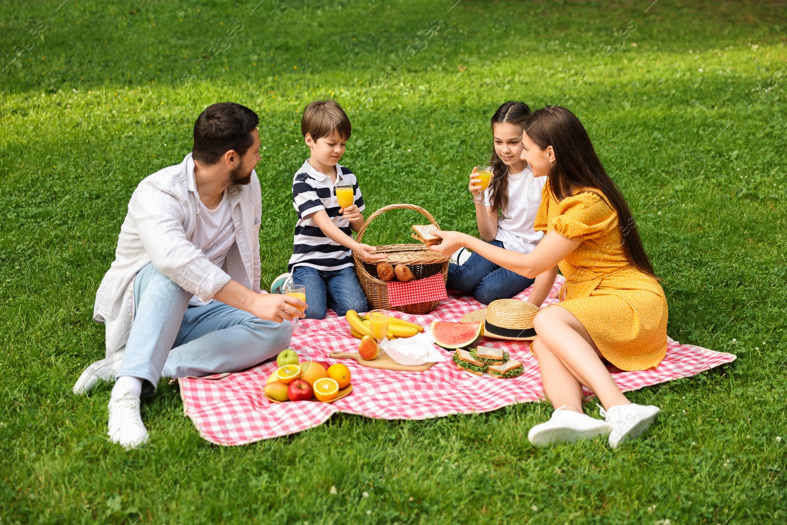 Photo of Lovely family having picnic together in park