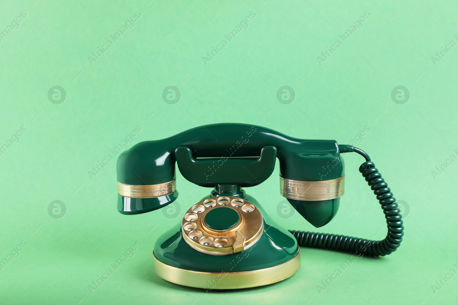 Photo of One telephone with handset on green background