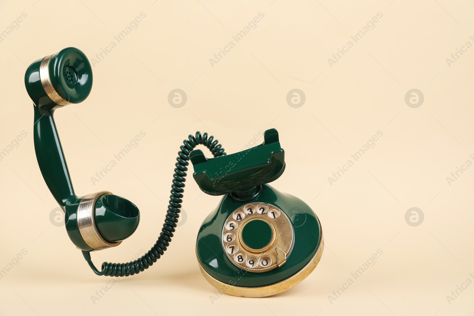 Photo of One green telephone with handset on beige background, space for text