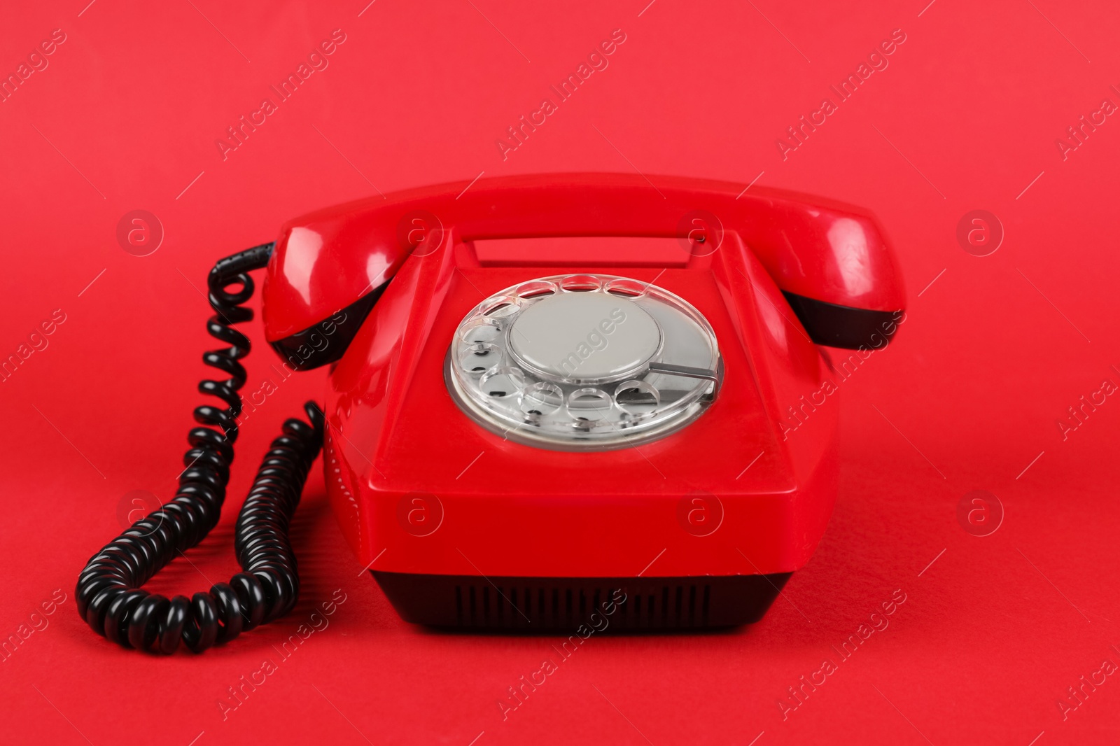 Photo of One telephone with handset on red background