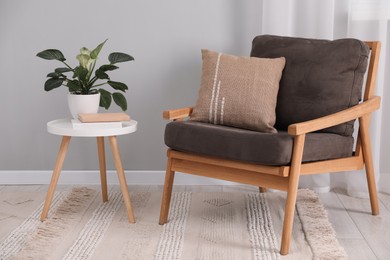 Photo of Soft pillow on armchair near coffee table indoors