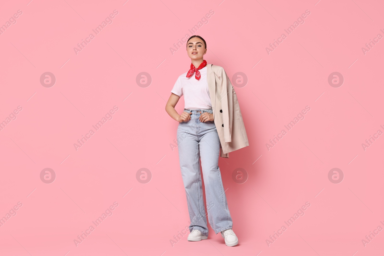 Photo of Stylish woman in beige jacket and jeans on pink background