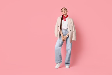 Photo of Stylish woman in beige jacket and jeans on pink background