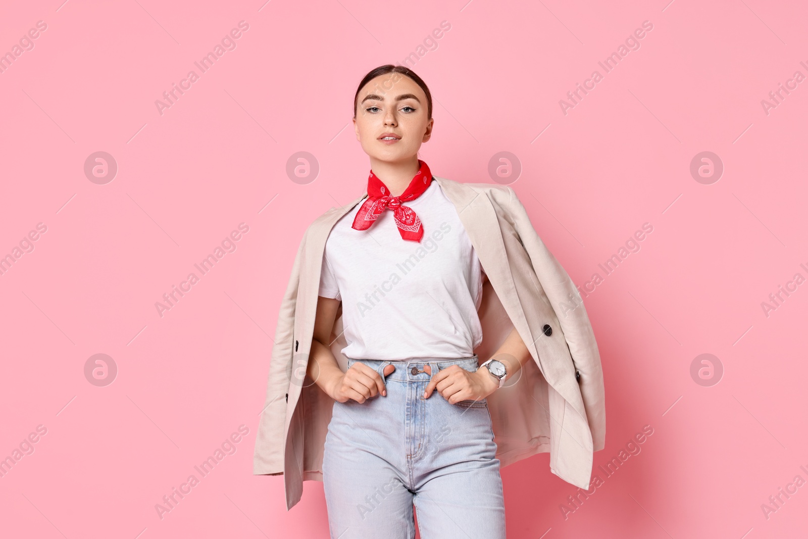 Photo of Stylish woman in beige jacket and jeans on pink background