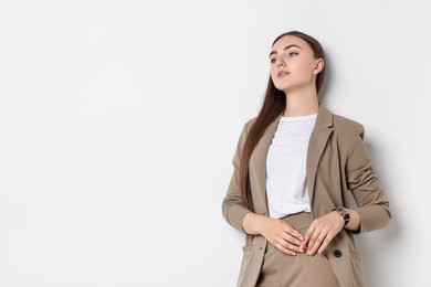 Photo of Beautiful woman in beige suit on white background, space for text