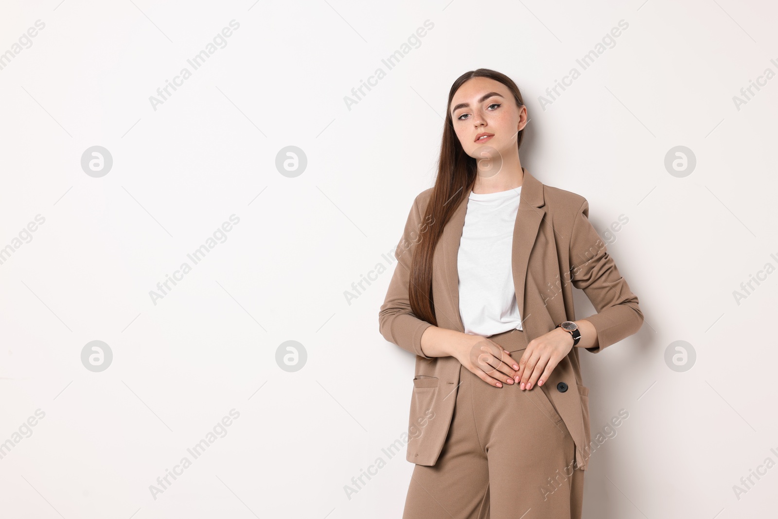 Photo of Beautiful woman in beige suit on white background, space for text