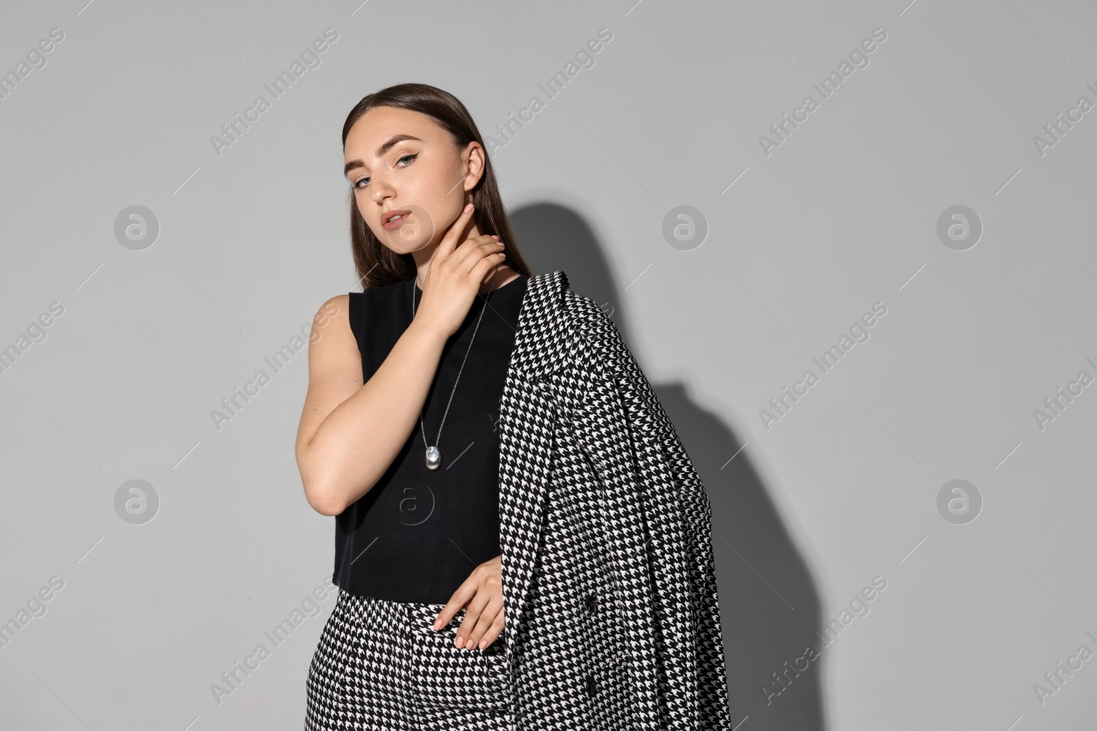 Photo of Beautiful woman in stylish suit on gray background