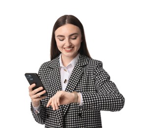 Beautiful woman in stylish suit with smartphone looking at wristwatch on white background