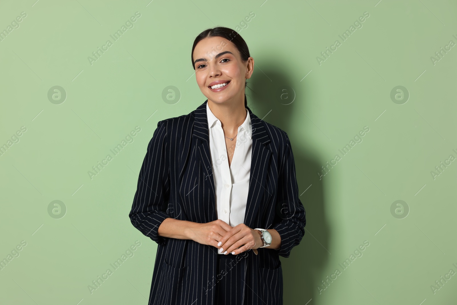 Photo of Beautiful woman in black striped suit on green background