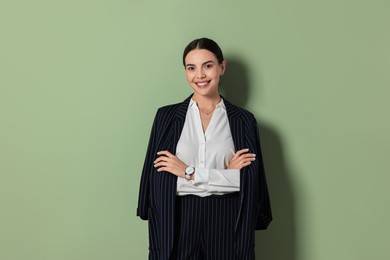 Beautiful woman in black striped suit on green background