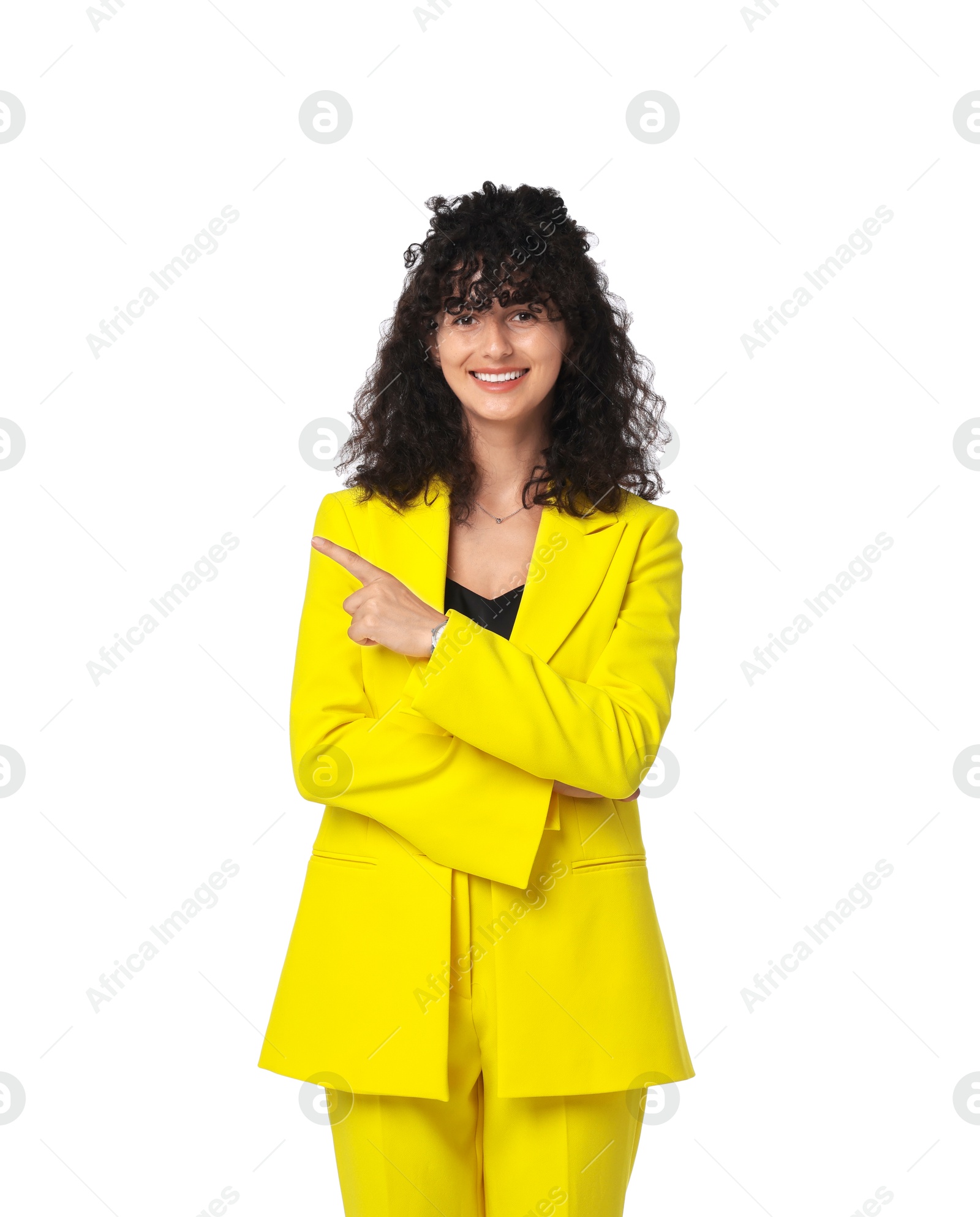 Photo of Beautiful young woman in stylish yellow suit pointing at something on white background