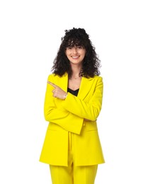 Beautiful young woman in stylish yellow suit pointing at something on white background