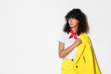 Beautiful young woman in stylish yellow suit on light background, space for text