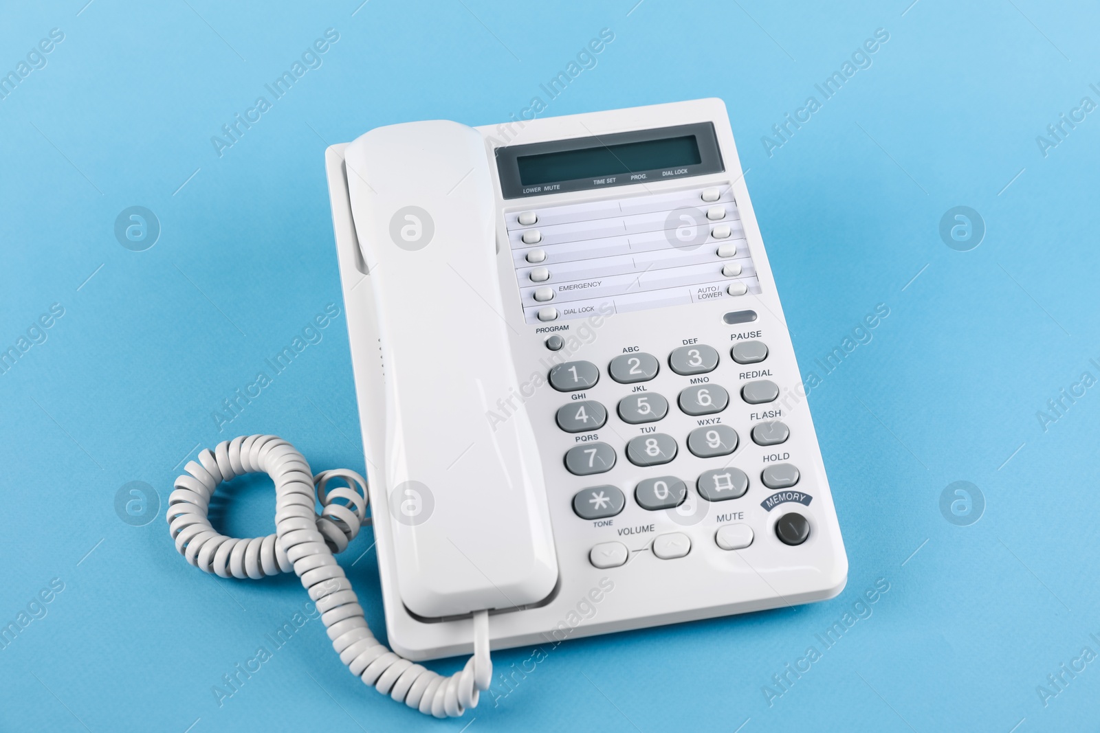 Photo of White telephone with handset on light blue background