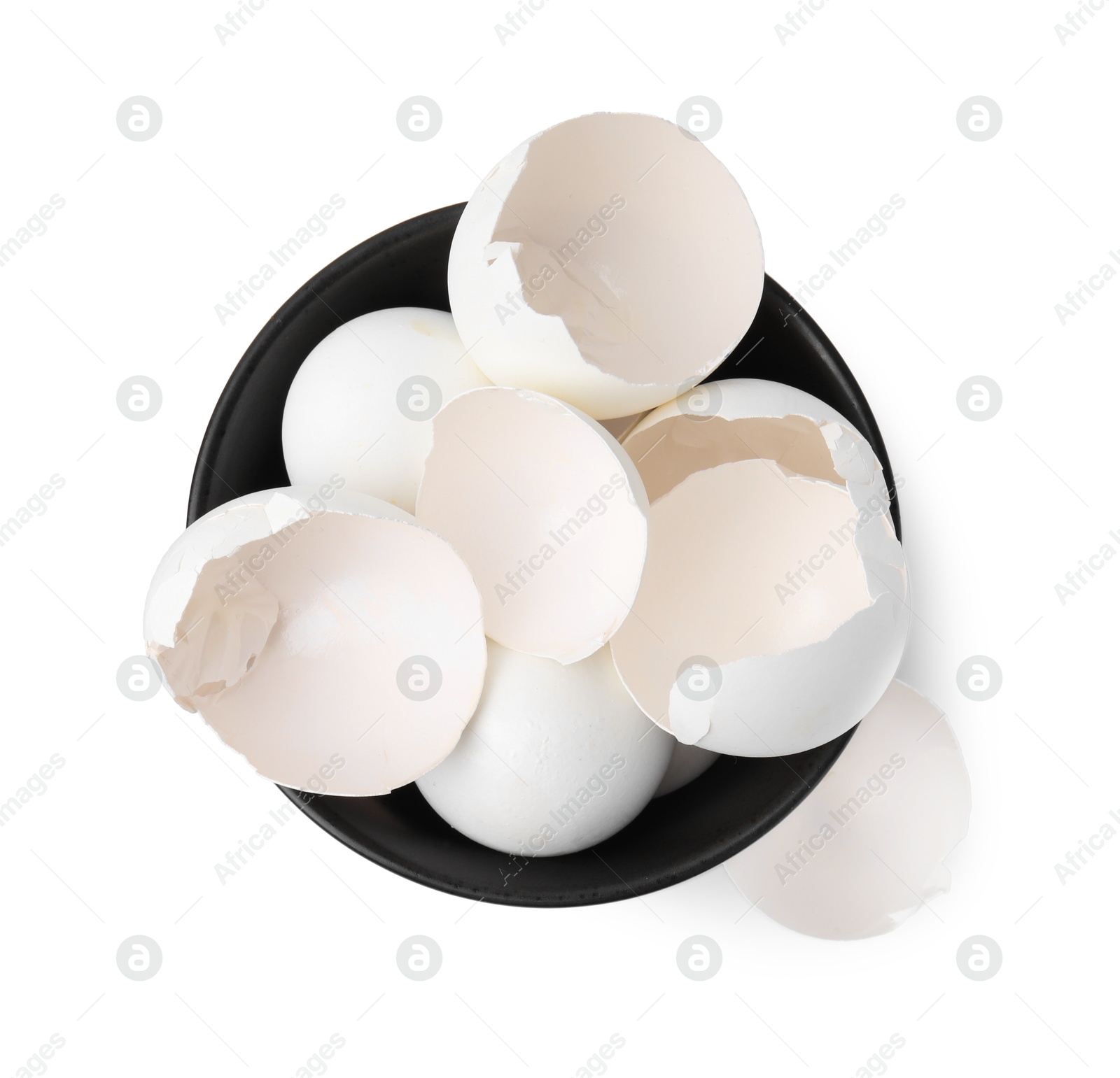 Photo of Broken eggshells in bowl isolated on white, top view