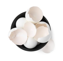 Photo of Broken eggshells in bowl isolated on white, top view