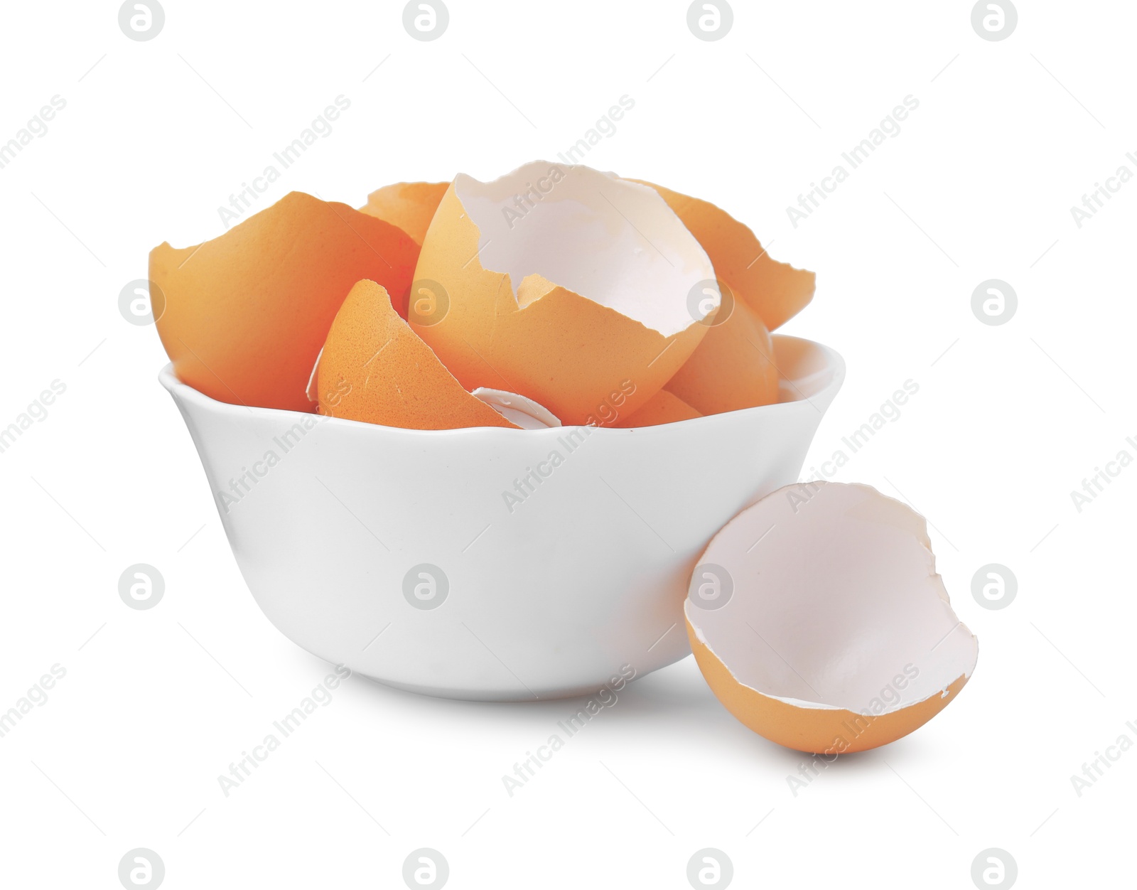 Photo of Broken eggshells in bowl isolated on white